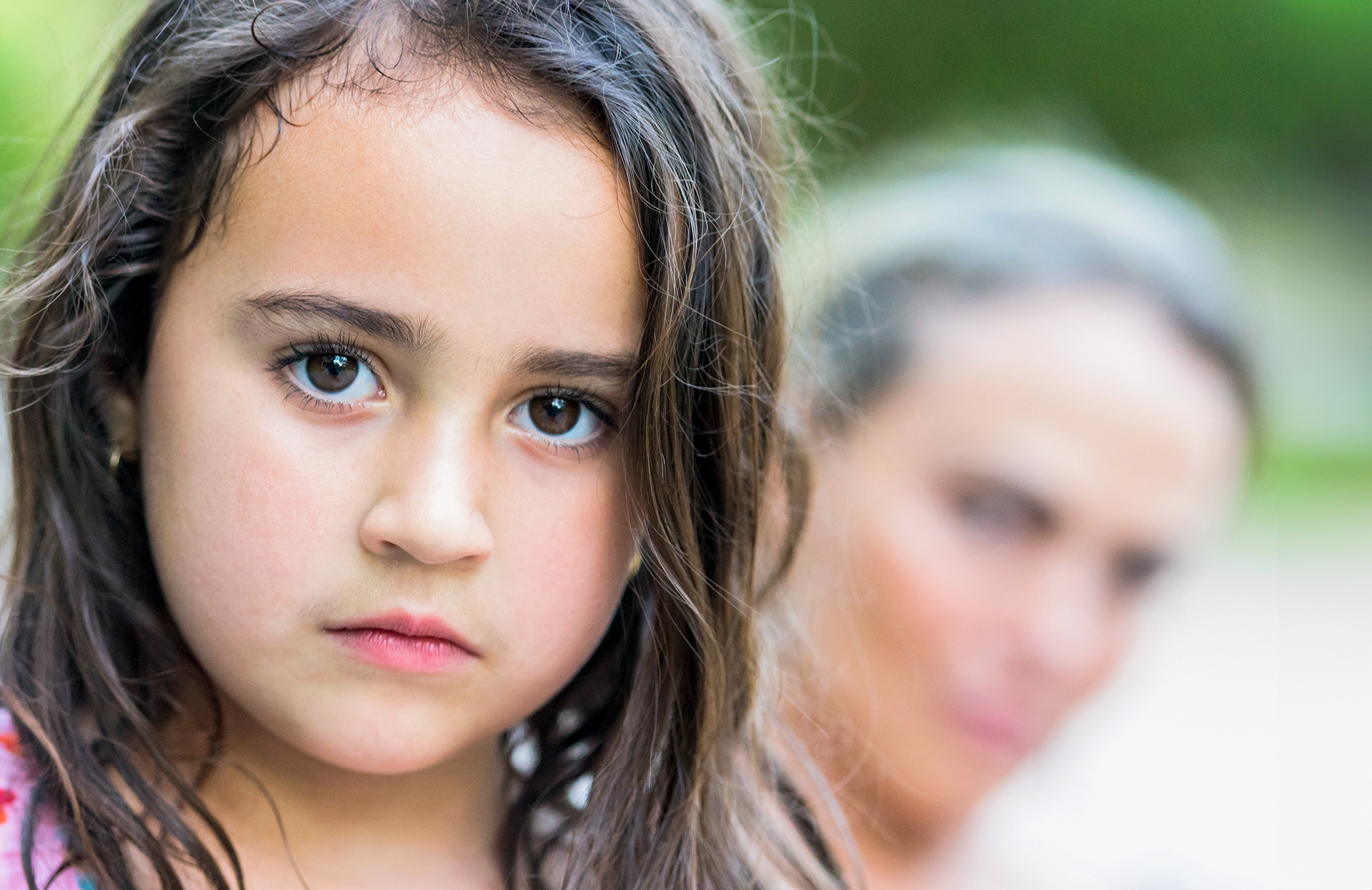 Image of young girl staring solemnly into the camera