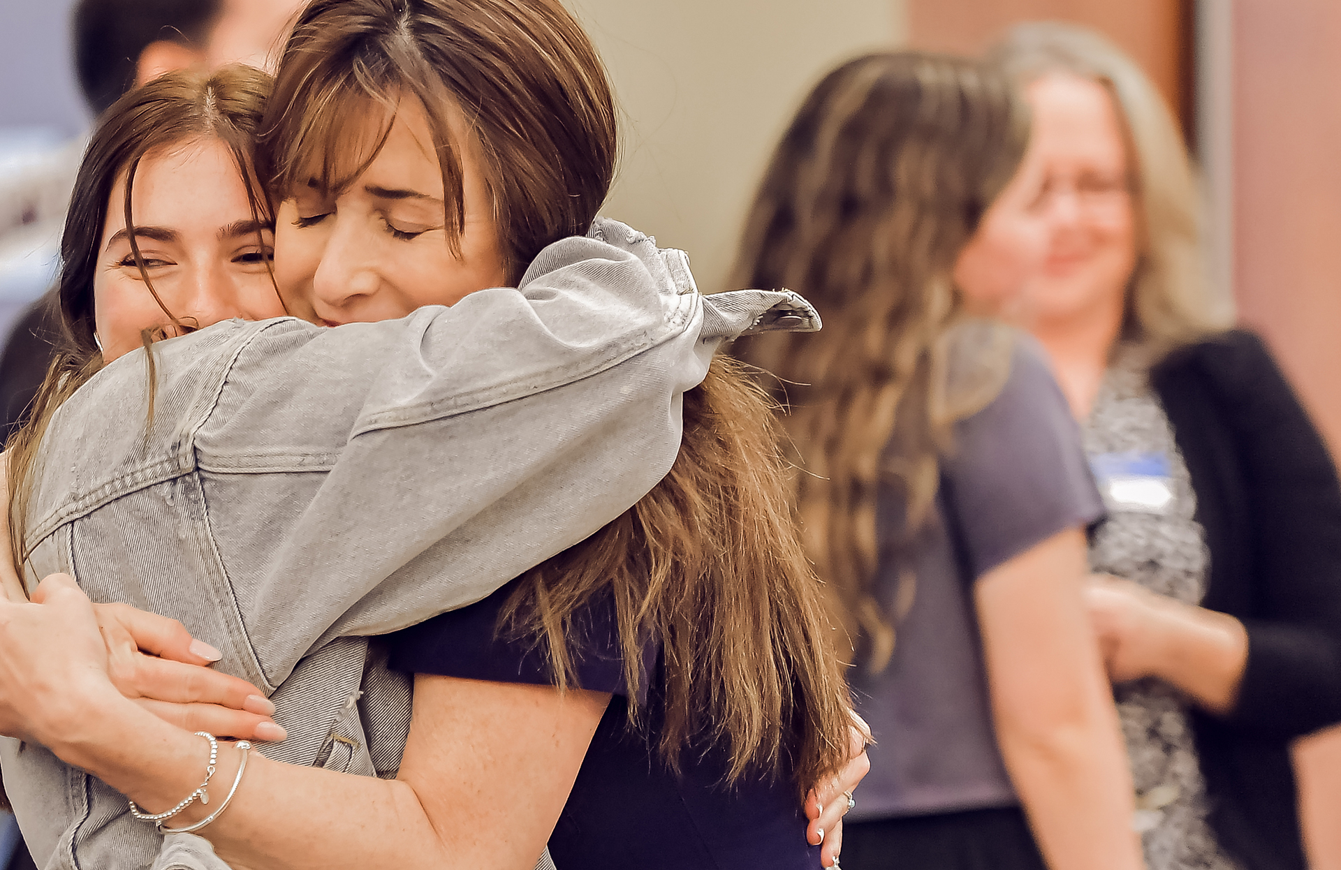 Image of a mother hugging her teenage daughter=